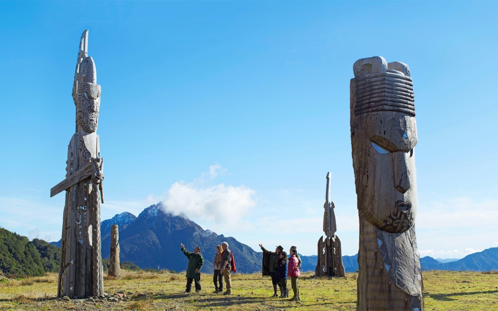 People standing amongst carved pou on top of Maunga Hikurangi